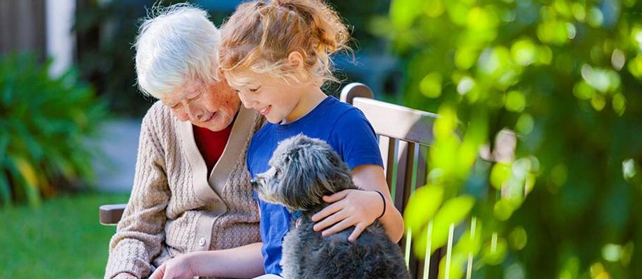 Aged care resident with her granddaughter and her pet dog