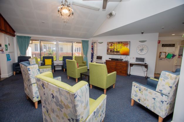 Large lounge room with chairs facing TV and musical equipment