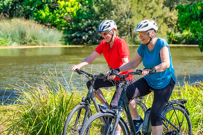 Lady and man on their bikes cycling along a bike path