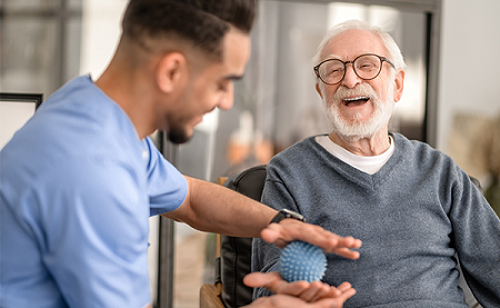 Student engaging with an older gentlemen in gentle exercise