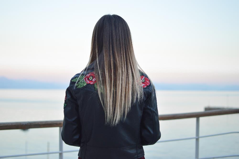 Lady faces away from camera overlooking water