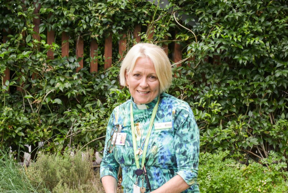 Lady stands smiling in garden